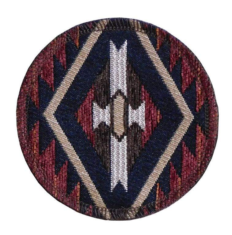 A round coaster with geometric patterns in red, beige, and black colors.