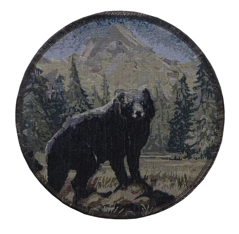 Round trivet with a bear and mountain design