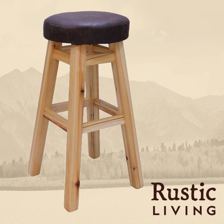 Rustic Farmhouse upholstered swivel bar stool handmade in America using solid wood custom made for your mountain cabin, lodge, farmhouse, ranch and western lifestyle. A rustic upholstered swivel bar stool with a brown cushion on a wooden base.