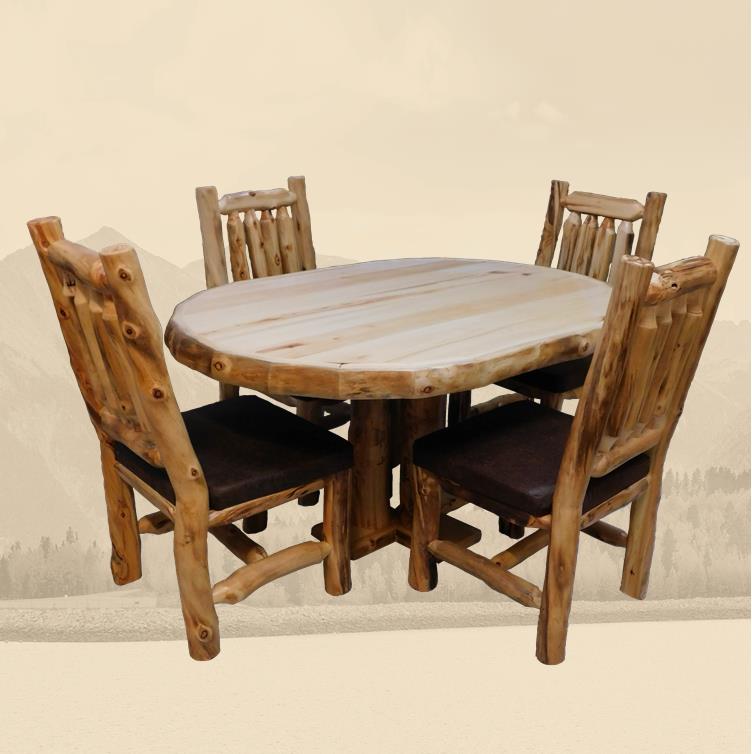 An oval-shaped rustic wooden dining table with a natural finish, accompanied by four matching chairs with dark cushions.